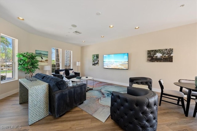 living room featuring visible vents, baseboards, and wood finished floors