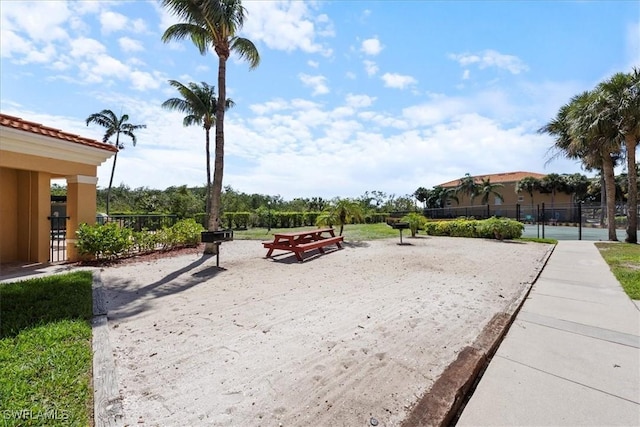 surrounding community with fence and volleyball court