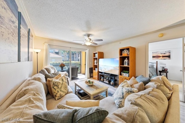 living area featuring ceiling fan, a textured ceiling, and ornamental molding