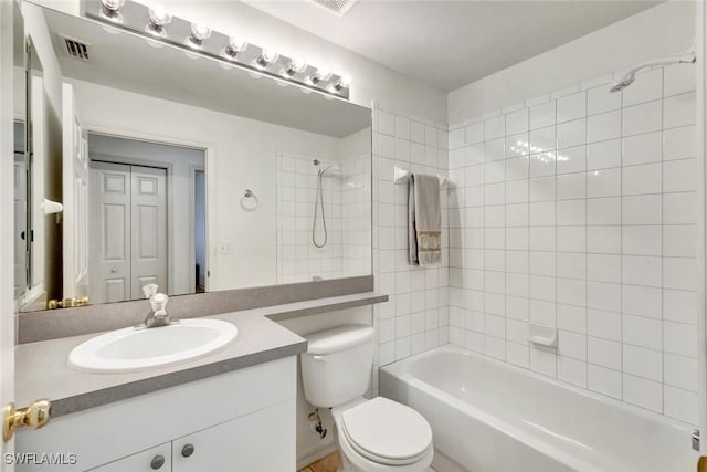 bathroom featuring toilet, vanity, visible vents, and bathing tub / shower combination