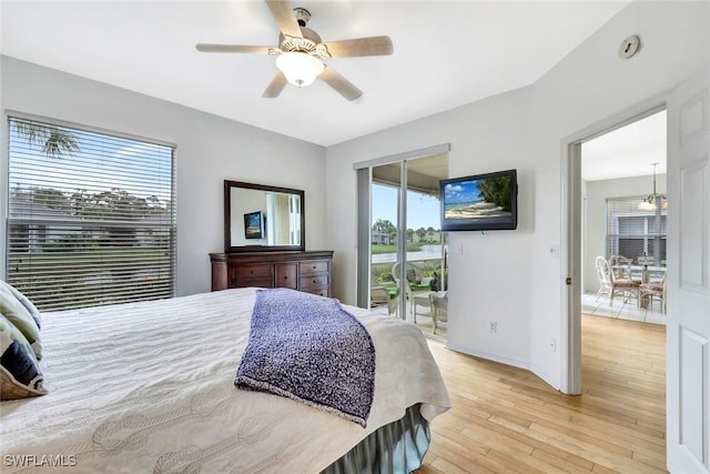 bedroom featuring access to exterior, multiple windows, a ceiling fan, and light wood-style floors