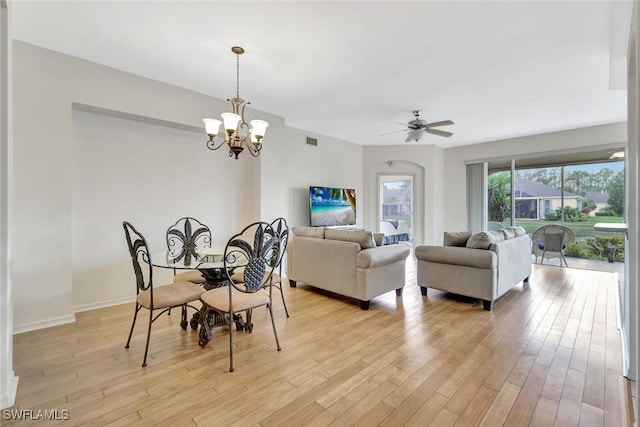 dining room with light wood finished floors, baseboards, visible vents, and ceiling fan with notable chandelier