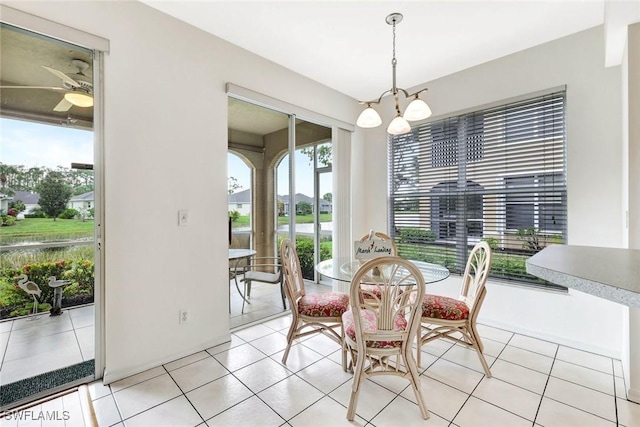 dining space with ceiling fan with notable chandelier and light tile patterned flooring