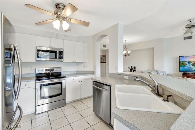 kitchen featuring light countertops, stainless steel appliances, a sink, and open floor plan