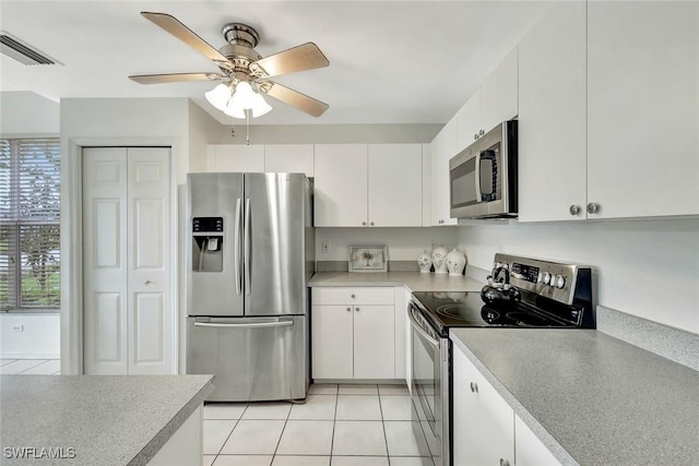 kitchen featuring light countertops, appliances with stainless steel finishes, a ceiling fan, white cabinetry, and light tile patterned flooring