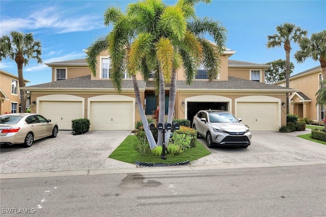 view of front facade with driveway, an attached garage, and stucco siding