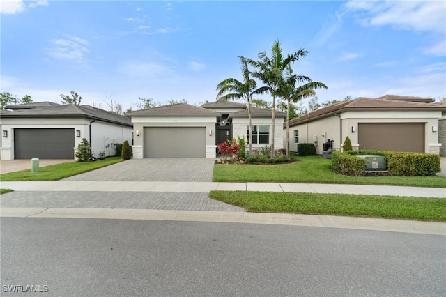 view of front of property with an attached garage, a front lawn, decorative driveway, and stucco siding