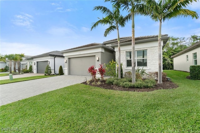 view of front of property featuring a garage, a front yard, and decorative driveway