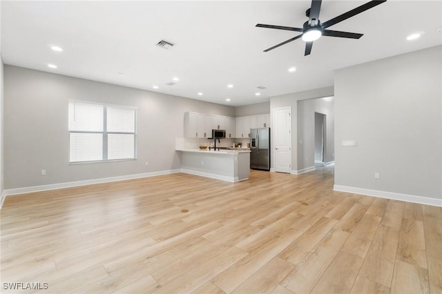 unfurnished living room with light wood finished floors, recessed lighting, visible vents, ceiling fan, and baseboards