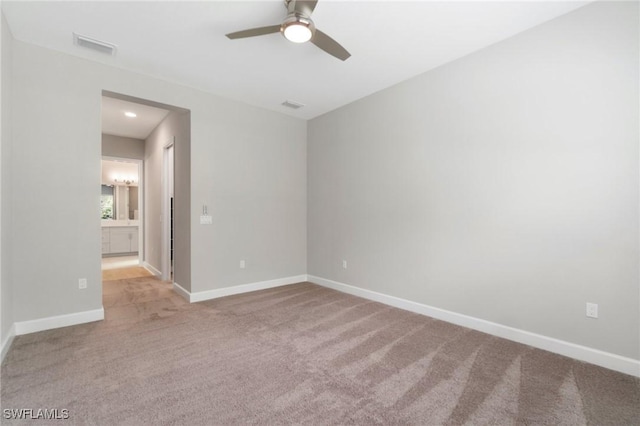 spare room featuring carpet, visible vents, and baseboards