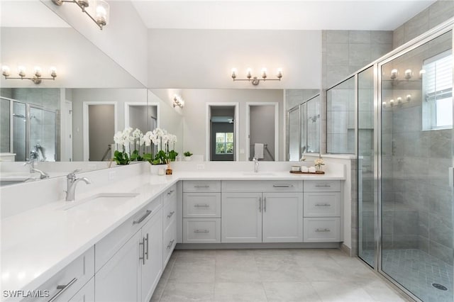 bathroom featuring double vanity, a stall shower, and a sink