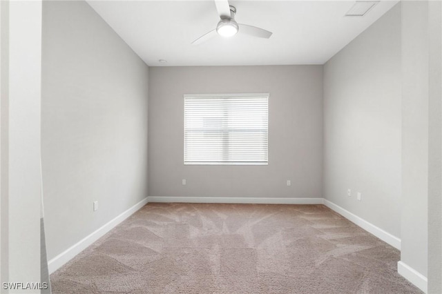 empty room with carpet floors, visible vents, baseboards, and a ceiling fan