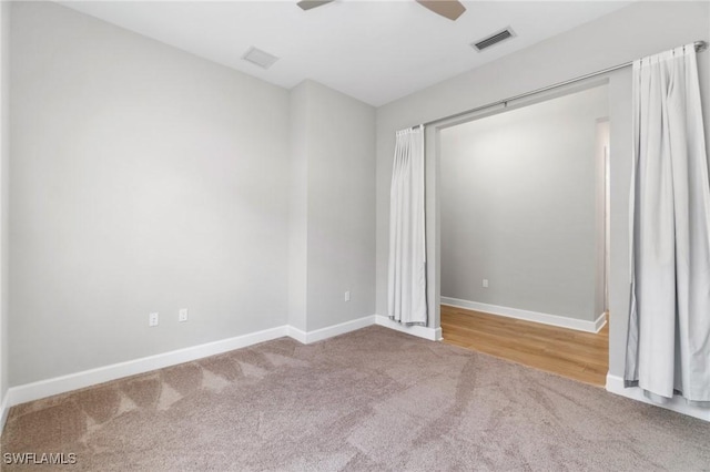 spare room featuring carpet floors, a ceiling fan, visible vents, and baseboards