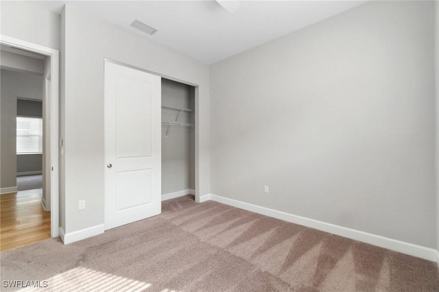 unfurnished bedroom featuring a closet, carpet, visible vents, and baseboards