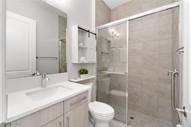 full bath featuring a stall shower, vanity, and toilet