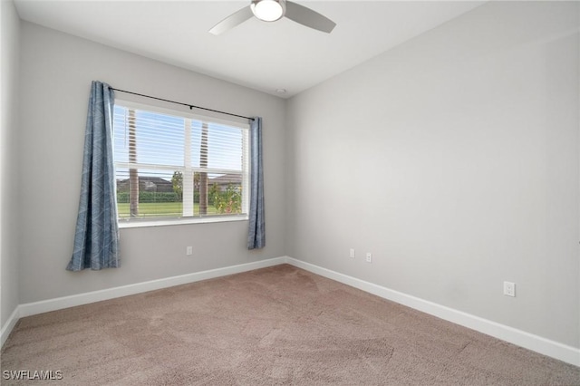 spare room with carpet floors, a ceiling fan, and baseboards