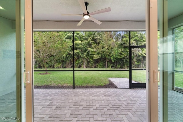 unfurnished sunroom featuring ceiling fan