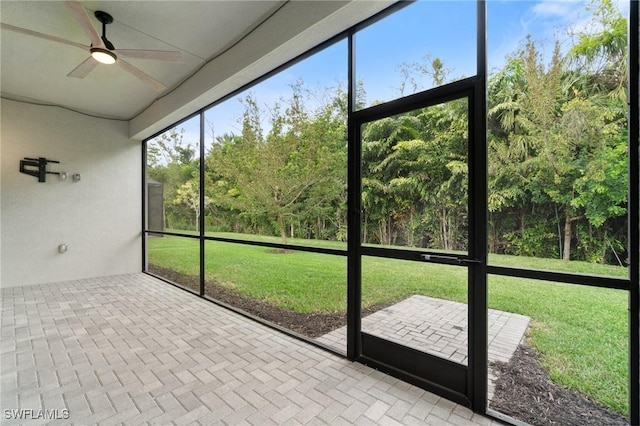 unfurnished sunroom with a ceiling fan and plenty of natural light