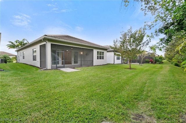 rear view of property featuring a lawn and a sunroom