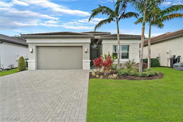 view of front facade featuring decorative driveway, stucco siding, a garage, a tiled roof, and a front lawn