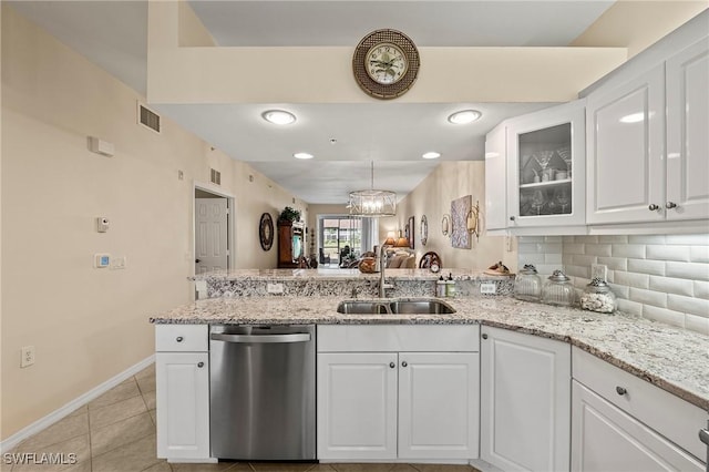 kitchen featuring dishwasher, a peninsula, light tile patterned flooring, white cabinets, and a sink