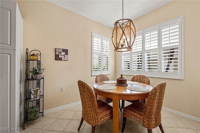 dining space with an inviting chandelier, light tile patterned flooring, and baseboards