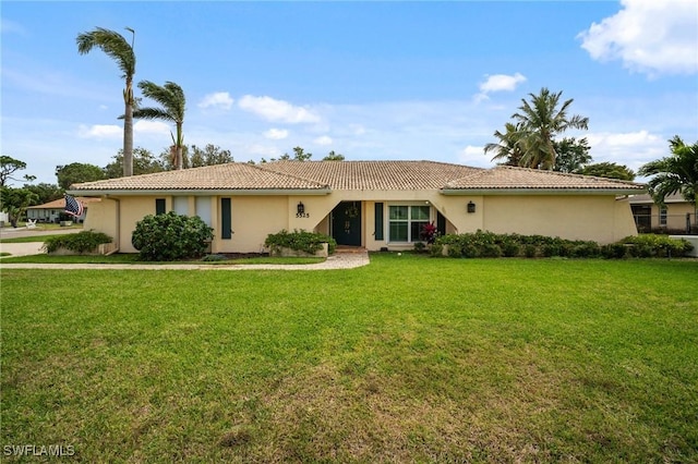 ranch-style home featuring stucco siding, a front lawn, and a tiled roof