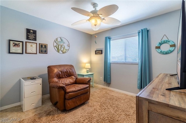 sitting room with ceiling fan, baseboards, and light colored carpet