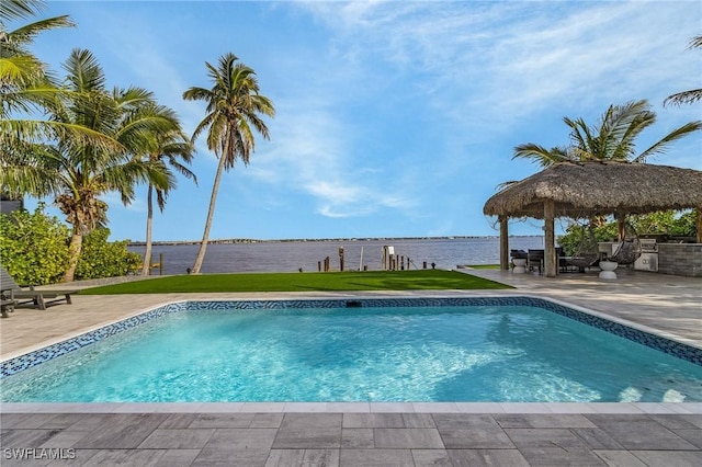 outdoor pool featuring a water view, a patio area, a yard, and a gazebo