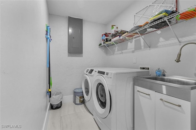 laundry area featuring cabinet space, electric panel, baseboards, washer and dryer, and a sink