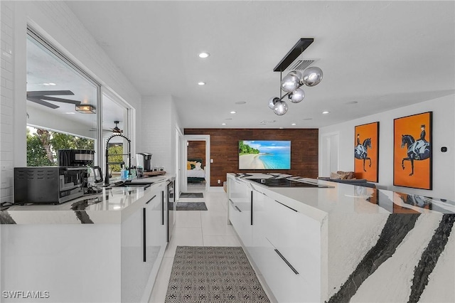 kitchen featuring white cabinets, modern cabinets, light tile patterned flooring, a sink, and recessed lighting