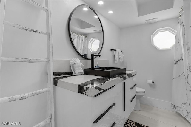 bathroom featuring toilet, recessed lighting, baseboards, and vanity