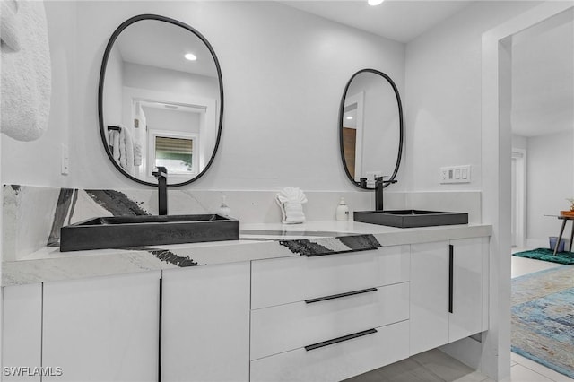 full bath with double vanity, a sink, and recessed lighting