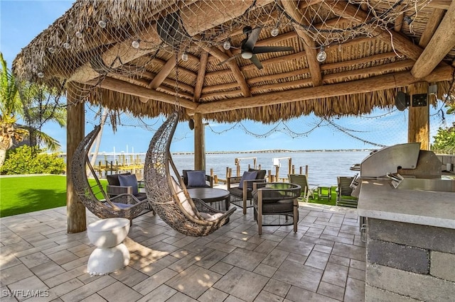 view of patio with area for grilling, a gazebo, a water view, and a ceiling fan