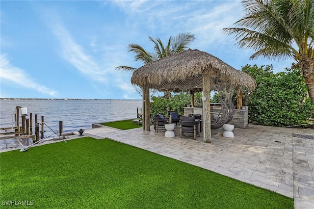 view of yard featuring a patio, a boat dock, and a water view