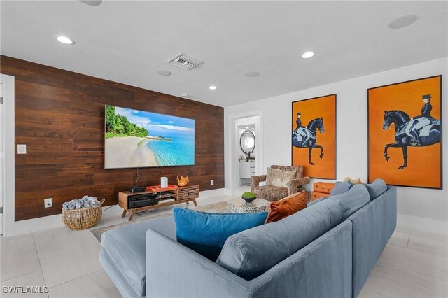 cinema room with an accent wall, recessed lighting, visible vents, and wood walls