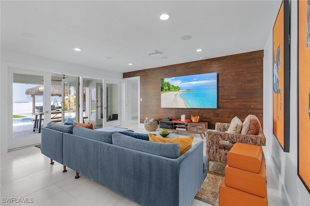 living room featuring recessed lighting, visible vents, and wood walls