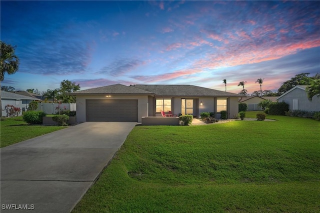 single story home featuring an attached garage, fence, driveway, a yard, and stucco siding