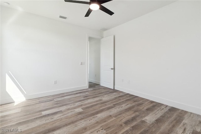 unfurnished room with light wood-style floors, visible vents, ceiling fan, and baseboards