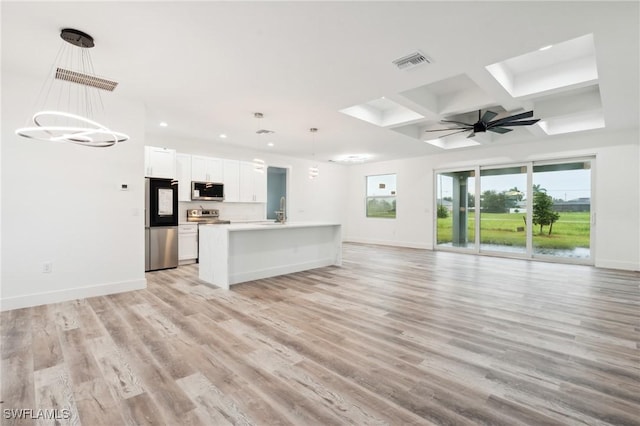 unfurnished living room with light wood-style floors, baseboards, visible vents, and ceiling fan with notable chandelier