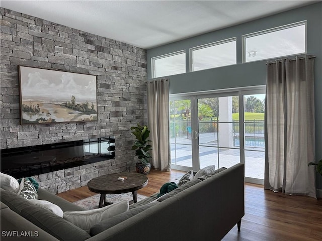 living room featuring wood finished floors and a stone fireplace