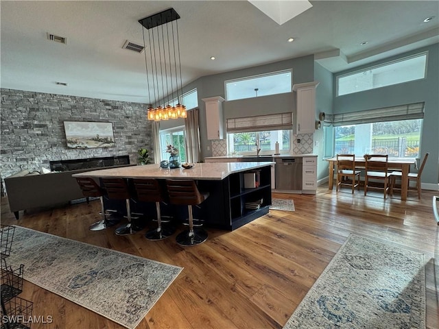 kitchen with visible vents, a center island, wood-type flooring, and decorative backsplash