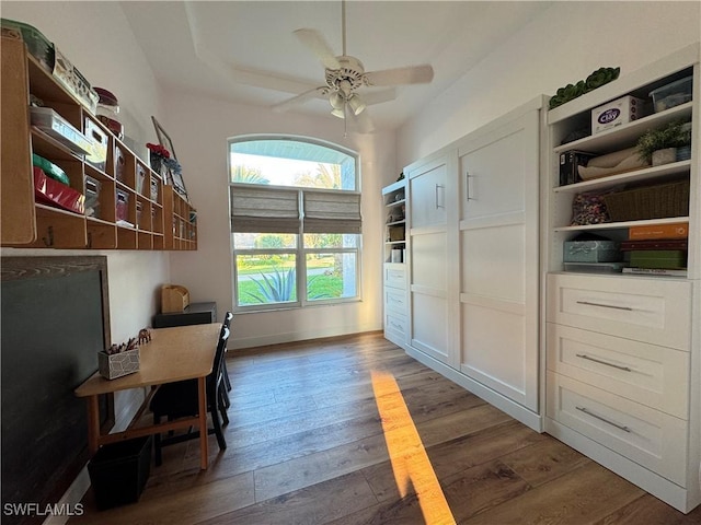 office area with baseboards, hardwood / wood-style flooring, a ceiling fan, and a raised ceiling