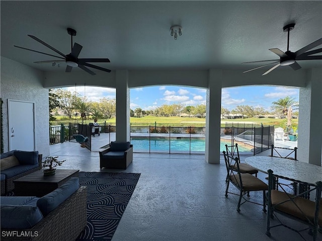 view of patio featuring outdoor lounge area, ceiling fan, a fenced in pool, and fence
