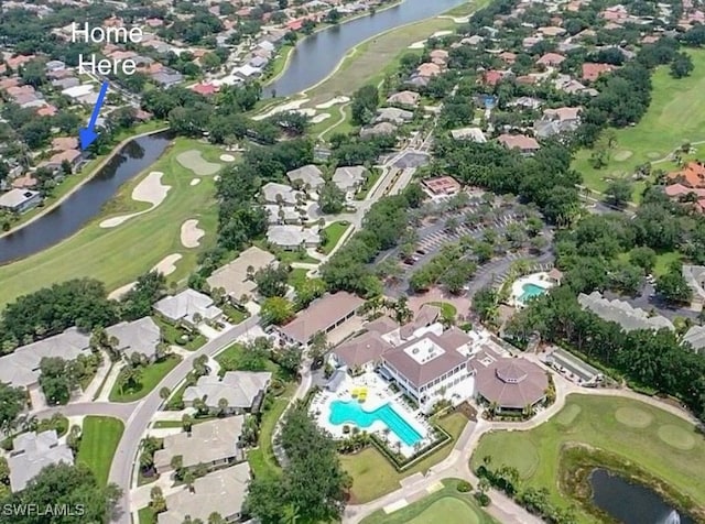 drone / aerial view with a water view, view of golf course, and a residential view