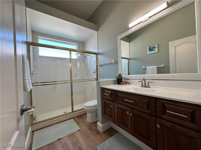 full bathroom featuring toilet, a shower stall, vanity, and wood finished floors
