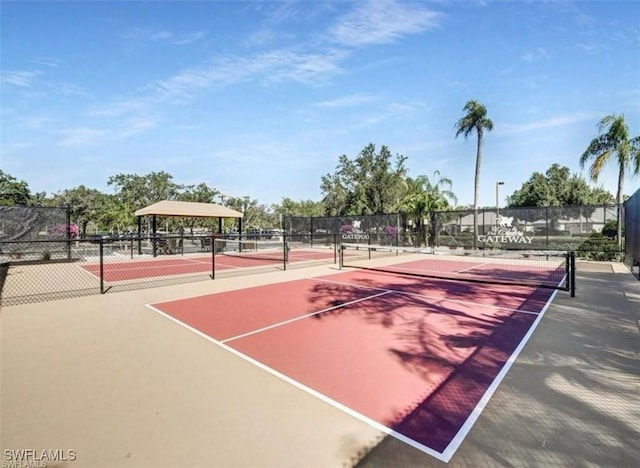 view of tennis court with community basketball court and fence