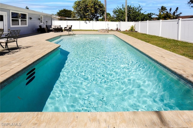 view of swimming pool with an outdoor living space, a fenced in pool, a patio, and a fenced backyard