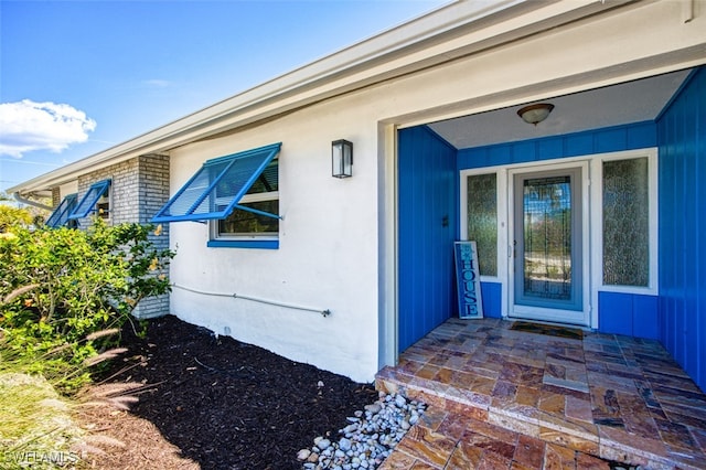 view of exterior entry featuring brick siding