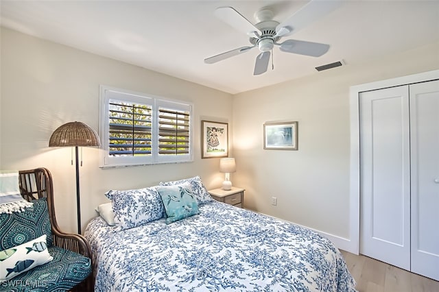 bedroom with ceiling fan, visible vents, a closet, and light wood-style flooring